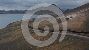 Aerial view of glacier lake of Skaftafell national park with offroad jeep driving dirt road exploring wilderness