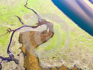 Aerial view of the Glaslyn Marshes close to the railway with the Snowdonia mountain range national park in background -