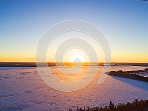 Aerial view of a gold sunset over winter snow-covered pine forest. Winter forest texture. Aerial view. Aerial drone view of a wint