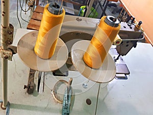 Aerial view of golden threads for sewing machines. Pair of spools of thread for embroidery in a clothing workshop