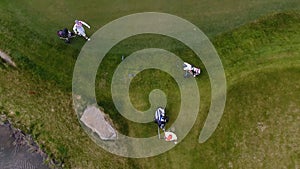 Aerial view Golf course. Golfers walking down the fairway on a course with golf bag and trolley