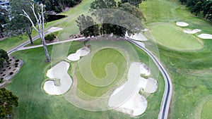 Aerial view of golf course green with flag, bunkers, dams, fairways Sydney Australia