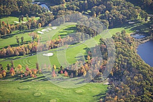 Aerial view of golf course and lake during autumn