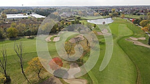 Aerial view of a golf course with ponds. Residential single family houses next to golf course.