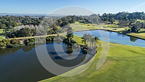 Aerial view of golf course with two water hazard dams, bunkers, and fairways