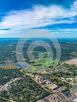 Aerial view of golf courses in a densely forested urban development