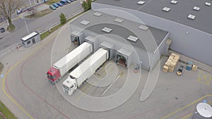 Aerial view. goods distribution warehouse. Semi trucks loading cargo containers. Logistics export and import cargo distribution