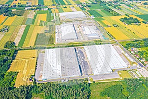 Aerial view of goods warehouse. Logistics center in industrial city zone from above. Aerial view of trucks loading at logistic