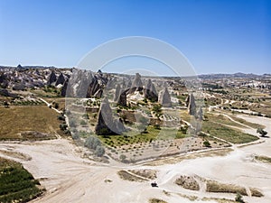 Aerial view of Goreme National Park, Tarihi Milli Parki, Turkey. The typical rock formations of Cappadocia. Tourists on quads