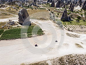 Aerial view of Goreme National Park, Tarihi Milli Parki, Turkey. The typical rock formations of Cappadocia. Tourists on quads photo