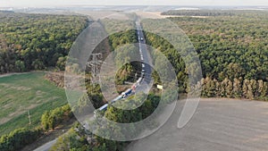 Aerial view. Grain storage. Grain trucks stand along the road in line to the granary. Trucks in traffic. Harvesting and