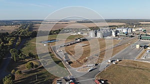 Aerial view. Grain storage. Grain trucks stand along the road in line to the granary. Trucks in traffic. Harvesting and