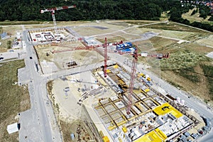 Aerial view from a greater height above the cranes of a construction site with the carcasses for new apartments in a growing Germa