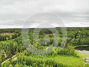 Aerial view of green forest and lake on a summer day in Finland. Drone photography