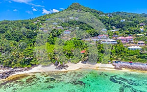 Aerial view of a green hill by Anse Royale shore