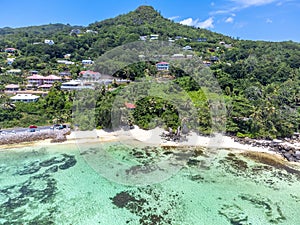 Aerial view of a green hill by Anse Royale shore