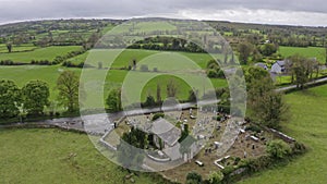 Aerial view green Ireland hinterland landscape. Drone point of view of green trees, meadow and cemetery in Ireland. No