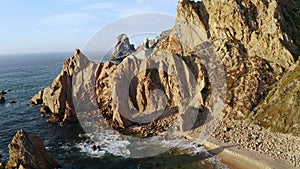 Aerial view of green island with mountain crag rocky cliffs surrounded stormy Atlantic ocean with Ursa deserted beach in