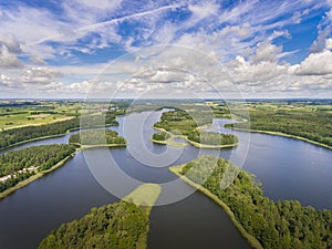 Aerial view of green islands and clouds at summer sunny day.Wydminy lake on Masuria in Poland.