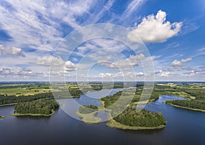 Aerial view of green islands and clouds at summer sunny day.Wydminy lake on Masuria in Poland.