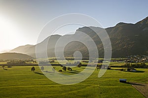 Aerial view of green meadows with villages and forest in austrian Alps mountains