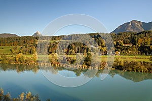 Aerial view of green meadows with villages and forest in austrian Alps mountains