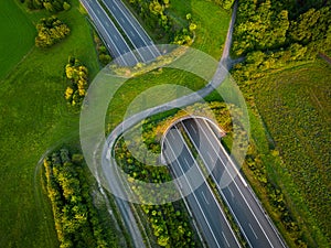 Aerial view of a green overpass over an empty highway during sunset