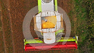 Aerial view of green and red combine harvester in field