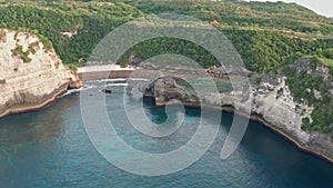 Aerial view of the green tropical coast of the island of Nusa Penida, Atuh beach, Bali, Indonesia.Clear blue ocean waves