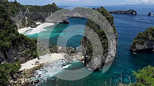 Aerial view of the green tropical coast with turquoise water and rocks of the island of Nusa Penida, Atuh Beach, Bali