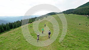 Aerial view group of cyclists men riding electric bikes outdoors in the mountains at summer.