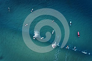 Aerial view of a group of surfers in the ocean at the Baleal beach in Peniche