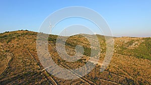 Aerial view of group of windmills on a sunny hill