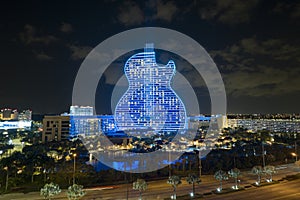 Aerial view of guitar shaped Seminole Hard Rock Hotel and Casino structure illuminated with bright neon colorful lights