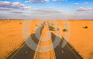 Aerial view of half desert road or street with sand dune in Dubai City, United Arab Emirates or UAE. Natural landscape background