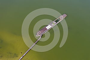 Aerial view of a half-sunken rusty barge at the last berth on the Ob River in Siberia, Russia, in summer