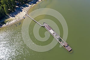 Aerial view of a half-sunken rusty barge at the last berth on the Ob River in Siberia, Russia, in summer