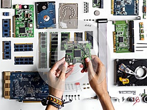 Aerial view of hands with computer electronics parts on white background