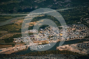 Aerial view of a harbor at a town in green hills on a sunny day