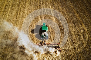 Aerial view of a harvester working in a field. Agriculture and cultivation of industrial farms. Agribusiness.