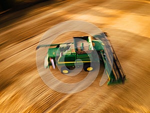 Aerial view of a harvester working in a field. Agriculture and cultivation of industrial farms. Agribusiness.