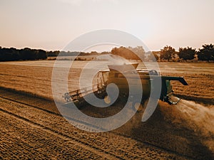 Aerial view of a harvester working in a field. Agriculture and cultivation of industrial farms. Agribusiness.