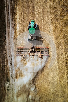 Aerial view of a harvester working in a field. Agriculture and cultivation of industrial farms. Agribusiness.