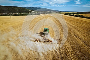 Aerial view of a harvester working in a field. Agriculture and cultivation of industrial farms. Agribusiness.