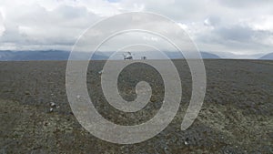 Aerial view of a helicopter and a group of hikers on a mountain top. Clip. Concept of adventure and tourism, people