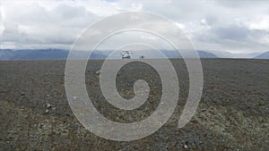 Aerial view of a helicopter and a group of hikers on a mountain top. Clip. Concept of adventure and tourism, people