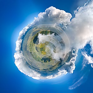 Aerial view from high altitude of little planet earth covered with white puffy cumulus clouds on sunny day