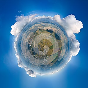 Aerial view from high altitude of little planet earth covered with white puffy cumulus clouds on sunny day