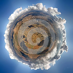 Aerial view from high altitude of little planet earth covered with white puffy cumulus clouds on sunny day