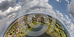 Aerial view from high altitude tiny planet in sky with clouds overlooking old town, urban development, buildings and crossroads.